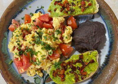 Scrambled eggs, avocado toast and refried beans.
