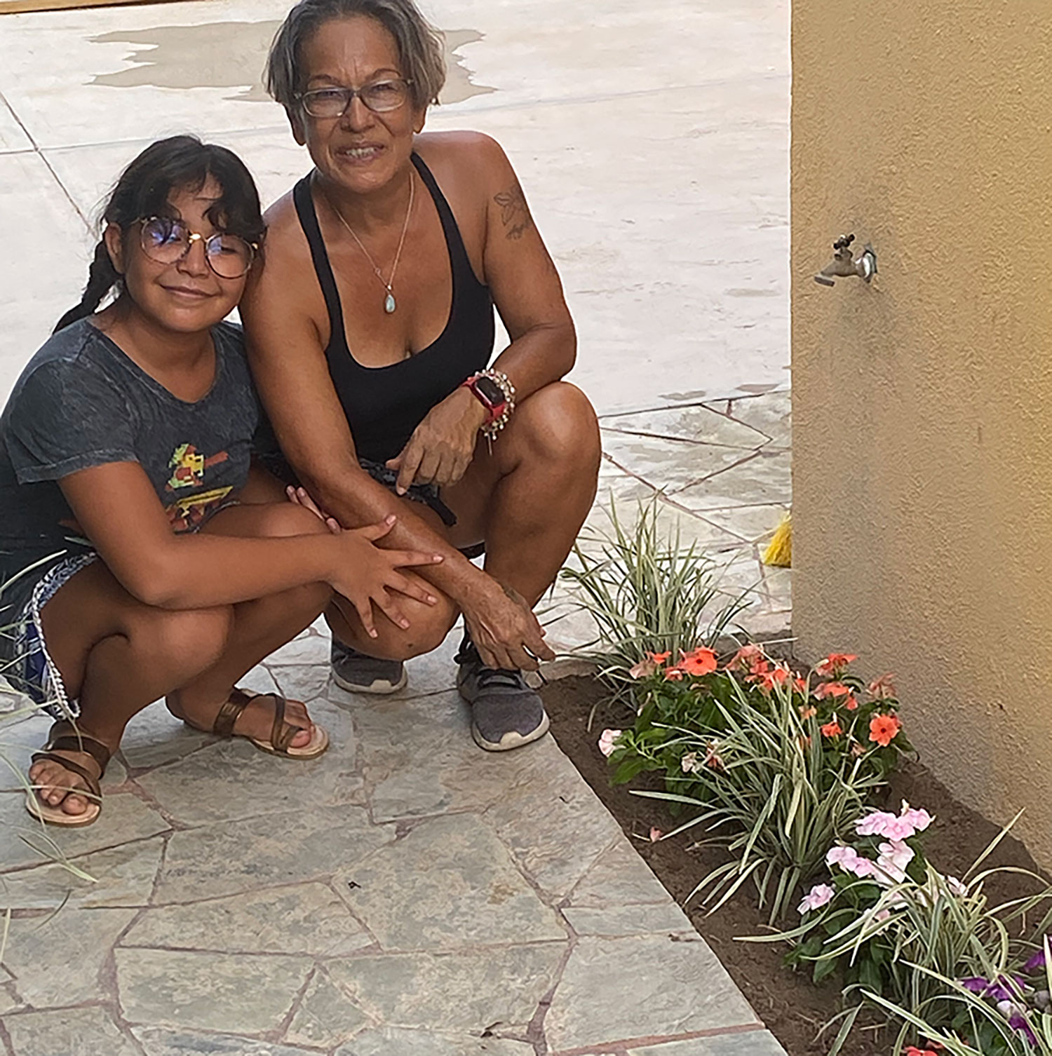 Inés and Mane with some newly-planted flowers at the front entrance to Zandoyo.