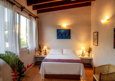 Queen size bed in Barbara, a second floor room at Zandoyo, offering quality accommodation in Puerto Escondido.
