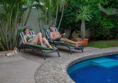 the cat and guests relax at poolside